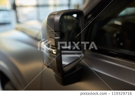 An elegant closeup shot of a sleek car side mirror showcasing its design and details An elegant closeup shot of a sleek car side mirror showcasing its design and details 119329716