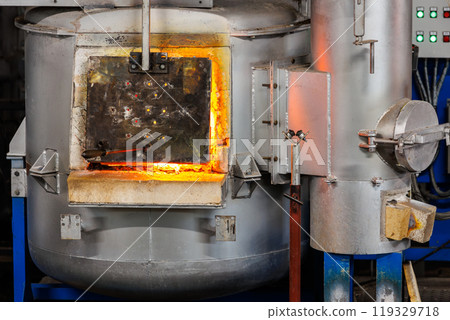 Industrial glassblowing furnaces actively running in glassware factory.  Glowing heat of glassmaking process. Handmade blowing glassware design production manufacture Europe 119329718