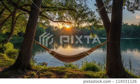 Relaxing hammock by a tranquil lake surrounded by lush trees on a sunny day 119331126