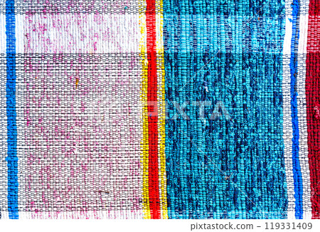 Old handmade homespun doormat from strips of cloth 119331409