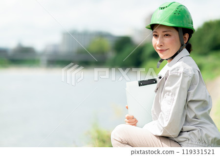 一名穿著工作服、戴著頭盔進行河流調查的婦女 119331521