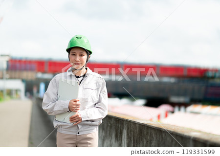 橋樑施工現場和一名穿著工作服、戴著頭盔的婦女 119331599