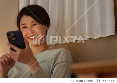 A woman watching a night smartphone A woman watching a night smartphone 119332243