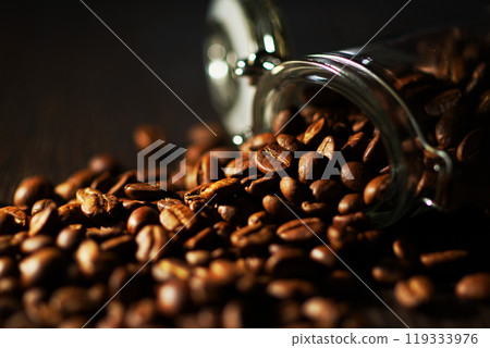 Coffee beans spilling from a coffee canister 119333976