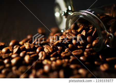 Coffee beans spilling from a coffee canister 119333977