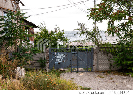 Episodes of war - view of city streets and houses after military actions The inscription in Russian is: People live here Episodes of war - view of city streets and houses after military actions The inscription in Russian is: People live here 119334205