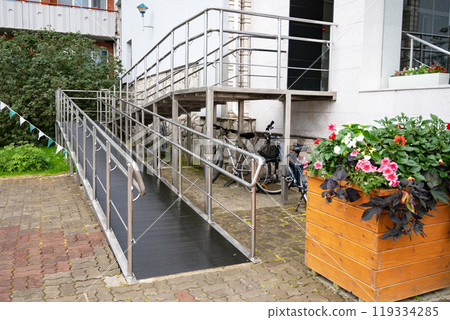 Modern building entrance with wheelchair ramp and stairs. Modern building entrance with wheelchair ramp and stairs. 119334285