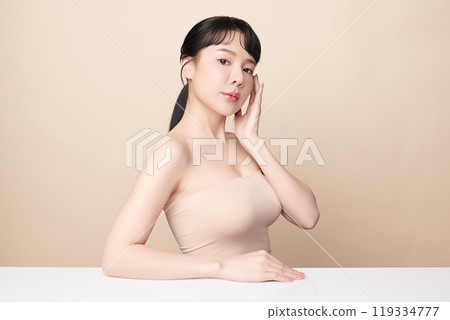 Beautiful young asian woman with clean fresh skin on beige background, Face care, Facial treatment, Cosmetology, beauty and spa, Asian women portrait. Beautiful young asian woman with clean fresh skin on beige background, Face care, Facial treatment, Cosmetology, beauty and spa, Asian women portrait. 119334777