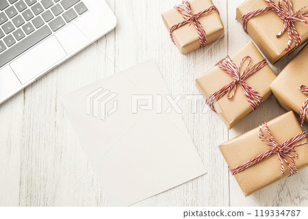Wrapped gifts and a blank note mock up for planning Christmas holiday surprises Wrapped gifts and a blank note mock up for planning Christmas holiday surprises 119334787