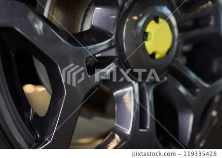Detailed shot of a sleek black and silver alloy wheel on a motor vehicle Detailed shot of a sleek black and silver alloy wheel on a motor vehicle 119335428