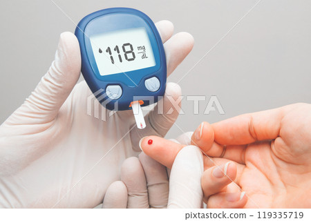 Person is taking their blood sugar reading 119335719