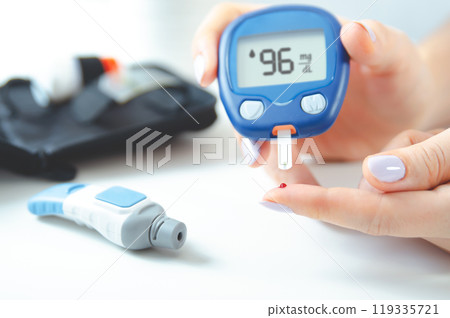 Woman is holding a blood glucose meter Woman is holding a blood glucose meter 119335721