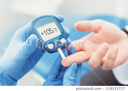 Person is taking a blood sugar reading Person is taking a blood sugar reading 119335727