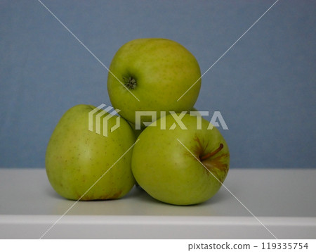 Golden Delicious apples at a blue background 119335754