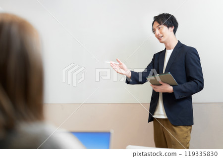 A man giving a lecture in front of a whiteboard A man giving a lecture in front of a whiteboard 119335830