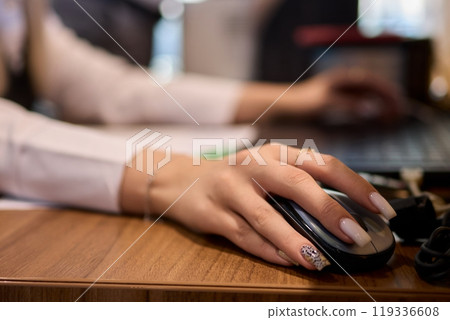 A Close Up View of a Hand Actively Using a Computer Mouse in a Professional Office Setting 119336608