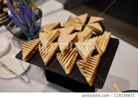 Indulge in Delicious Grilled Sandwiches Served on an Elegant Black Tray for Everyone 119336631