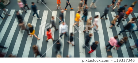 A top-down view of a busy crosswalk with people walking in various directions. The image highlights urban movement and daily life in a city. 119337346