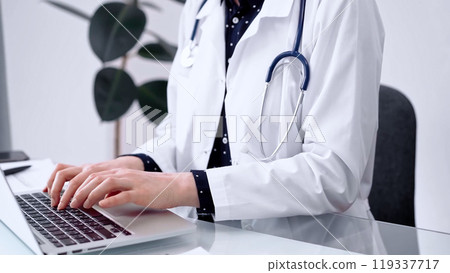 Doctor woman is using laptop computer at glass table in clinic. Medicine and pharmacy concept 119337717