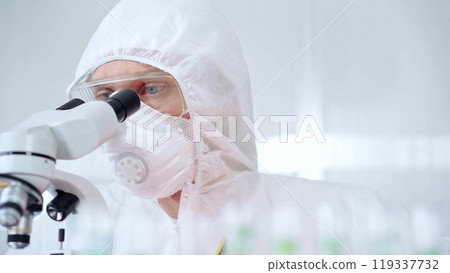 Professional scientist in protective gear is using microscope in a laboratory setting, close-up of researcher. Science and medicine concepts 119337732