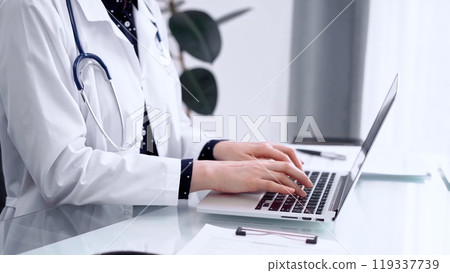 Doctor woman is using laptop computer at glass table in clinic. Medicine and pharmacy concept 119337739