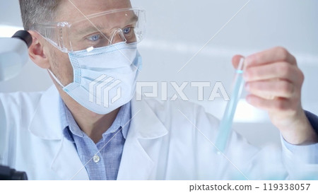 Scientist researcher with protective glasses and mask examining 119338057