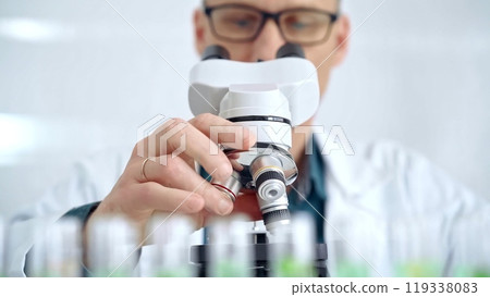 Man scientist with protective glasses using microscope in laboratory. Microbiology science concept Man scientist with protective glasses using microscope in laboratory. Microbiology science concept 119338083