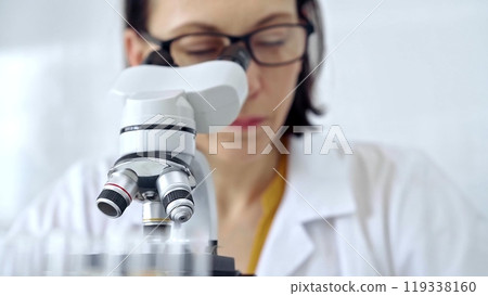 Woman scientist using microscope in laboratory. Microbiology science concept 119338160