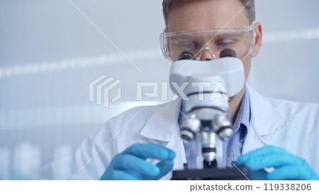 Man scientist with protective glasses and gloves is using microscope in laboratory, portrait of researcher. Microbiology science concept 119338206