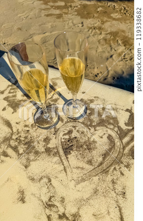 Two glasses of champagne draped with a heart from the sand . High quality photo 119338682