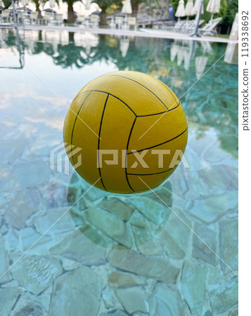 Water polo. Yellow water polo ball in a swimming pool in hotel on the beach. High quality photo 119338692