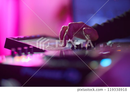 control DJ for mixing music with blurred people dancing at party in nightclub. control DJ for mixing music with blurred people dancing at party in nightclub. 119338918