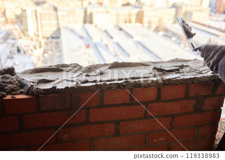 professional construction worker laying bricks and building barbecue in industrial site. Detail of hand adjusting bricks professional construction worker laying bricks and building barbecue in industrial site. Detail of hand adjusting bricks 119338983