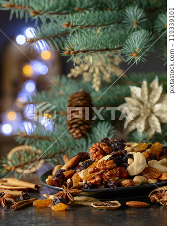 Christmas spices, various nuts, raisins, and dry citrus slices on a kitchen table. Christmas spices, various nuts, raisins, and dry citrus slices on a kitchen table. 119339101