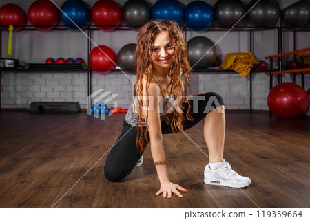 Energetic woman dancing in a fitness studio during a workout session 119339664