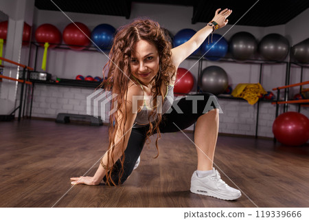 Energetic woman dancing in a fitness studio during a workout session 119339666