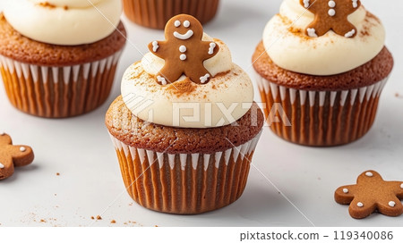 Gingerbread cupcakes with cream frosting and gingerbread man decoration on top, perfect for festive occasions. 119340086