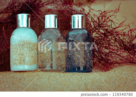 Cosmetics bottles - shampoo, shower gel, body lotion on sandy coast, red seaweed Cosmetics bottles - shampoo, shower gel, body lotion on sandy coast, red seaweed 119340780
