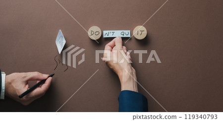 Top view of male and female hands assembling a Do it or Dont quit sign 119340793