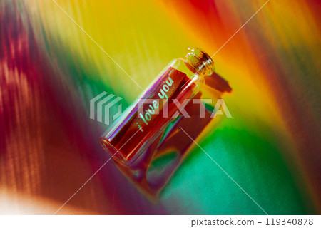 Love message in a glass bottle. Text 'I love you' in a jar on multicolored rainbow background. Confession for Valentine's Day. LGBT concept. 119340878