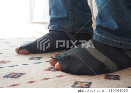 men feet with dirty socks while sitting on sofa  119341083