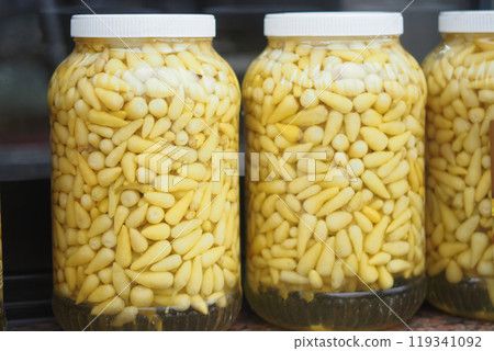 Beautifully arranged jars of vibrant and pickled yellow vegetables displayed attractively Beautifully arranged jars of vibrant and pickled yellow vegetables displayed attractively 119341092