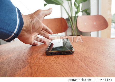 man hand picking up smart phone mobile to receive a call  119341135
