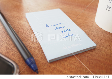 To do list in notebook with office suppliers on desk. To do list in notebook with office suppliers on desk. 119341161