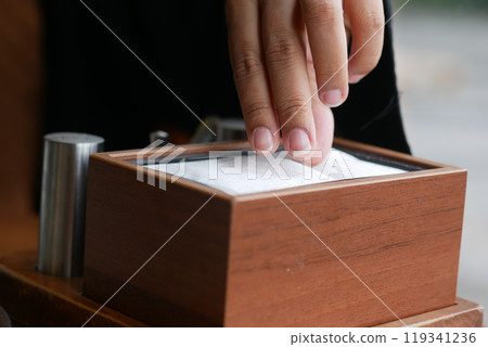 hand pull out a piece of tissue from tissue paper box  119341236