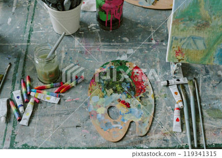 Top down shot of dirty wooden palette with acrylic paints, brushes and canvas on old table top Top down shot of dirty wooden palette with acrylic paints, brushes and canvas on old table top 119341315