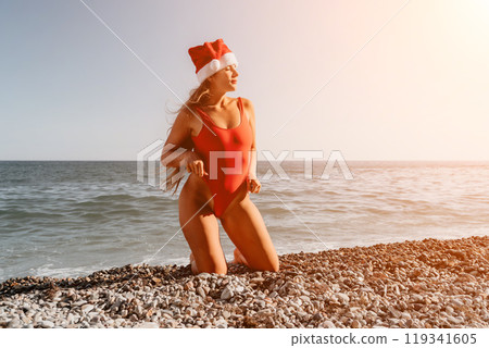 Woman in a Red Swimsuit and Santa Hat on the Beach 119341605