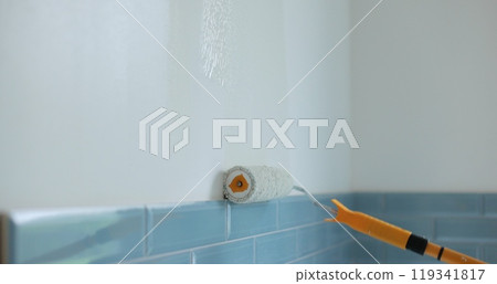 Man worker using roller to paint the walls in the house in white color. Room renovations at house. Man worker using roller to paint the walls in the house in white color. Room renovations at house. 119341817