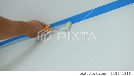 Man worker hand painting the wall inside the house and building. Builder, tools, apartment renovation. 119341818