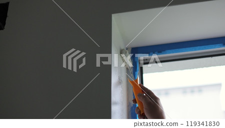Man paints the wall with a roller with white paint. Concept of home renovation, renovation in the apartment. 119341830